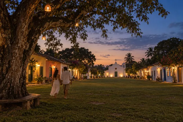 Casas coloridas e árvores do Quadrado de Trancoso, cena criada com IA